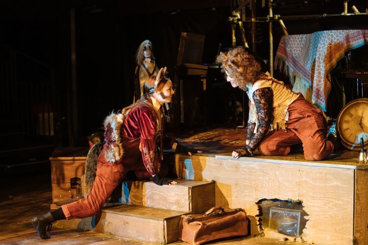 Opera singers in animal style costume kneeling on stage